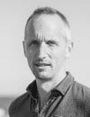 Man with short hair smiles into the camera