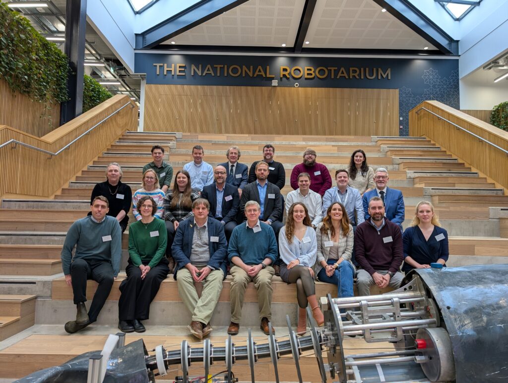 A group of people sitting in an atrium smiling at the camera